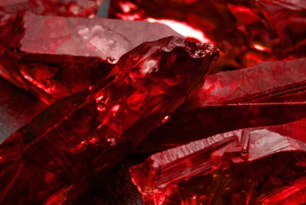 piedra rubi , mineral rubi , cristal rubi, gema de rubí rojo intenso sobre fondo neutro, símbolo de pasión, coraje y protección energética
