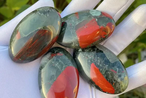 piedra sangre , mineral sangre , cristal mineral, piedra de sangre verde con motas rojas sobre fondo neutro, símbolo de vitalidad, coraje y protección energética