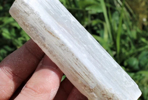 mineral selenita , piedra selenita , cristal piedra, barra de selenita blanca sobre fondo neutro, símbolo de limpieza energética, calma mental y conexión espiritual
